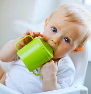 Малыш пьет из зеленой кружки