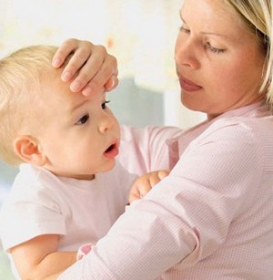 Мама определяет температуру ребенка рукой