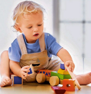 Ребенок играет с деревянными игрушками