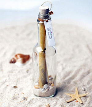 Бутылка с письмом внутри на песке