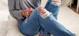 Девушка сидит в рваных джинсах