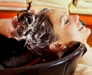 Девушке моют голову в салоне