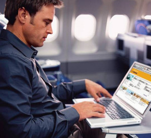 Мужчина работает за ноутбуком в самолете
