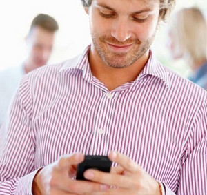 Мужчина в полосатой рубашке смотрит в телефон