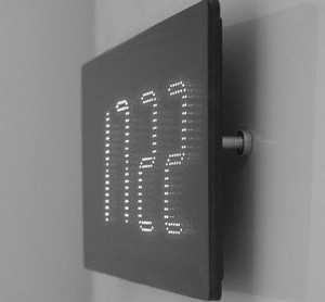 Электронные часы черного цвета висят на стене