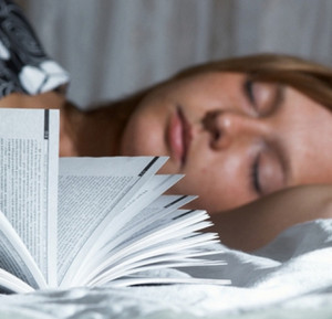Женщина спит перед открытой книгой