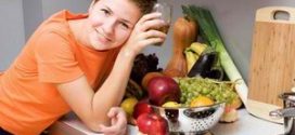 Девушка стоит рядом со столом с овощами и фруктами