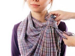 Девушке завязывают шарф на шее
