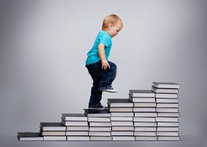 Мальчик ходит по книгам в виде лестницы