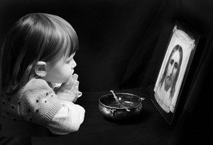 Ребенок молится возле иконы
