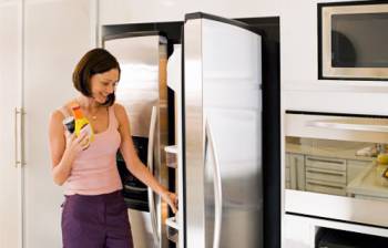 девушка достает из холодильника продукты