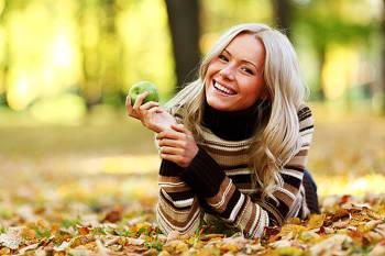 девушка с яблоком на осенних листьях
