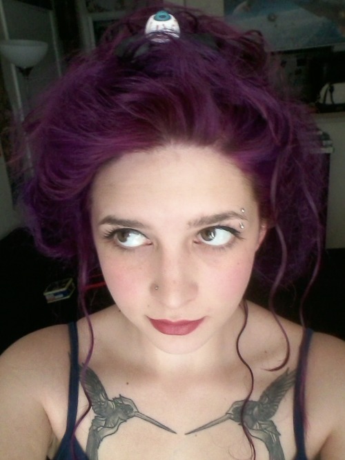 Девушка с проколом брови и фиолетовыми волосами