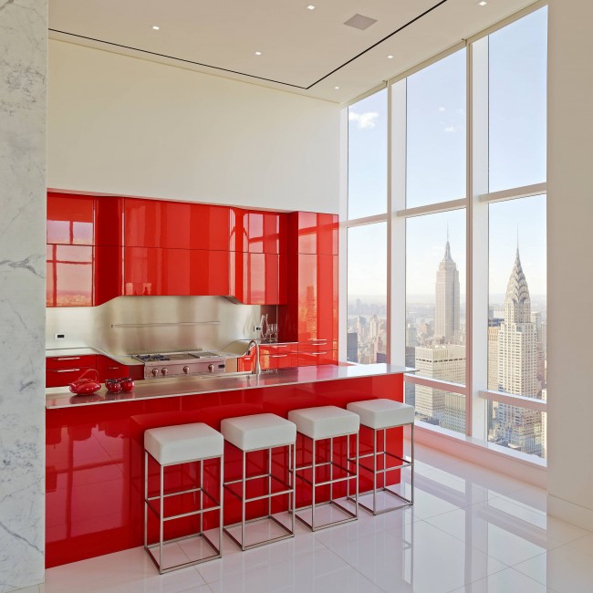 Яркий красный гарнитур акцентирует внимание на рабочей зоне кухни-студии