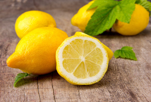 Лимон в разрезе. За ним целые плоды