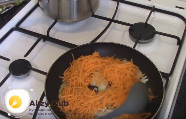 Добавляем к луку натертую на терке морковку и пассеруем овощи до мягкости.