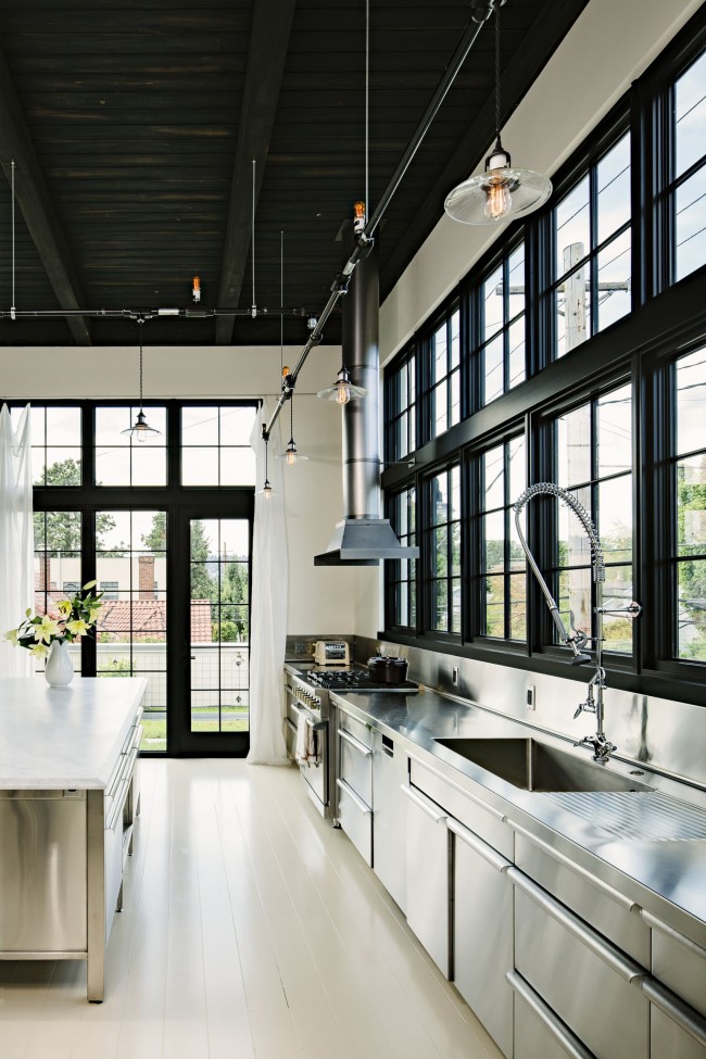 Большая современная кухня в черно-белых тонах в частном доме, с большими окнами, которые обеспечивают максимальное естественное освещение в дневное время суток