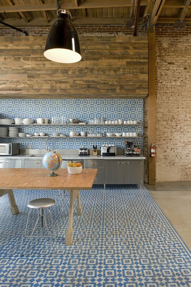 Очень смелое решение для зонирования кухни-студии, в котором кухонная зона выделена оригинальной орнаментальной плиткой 