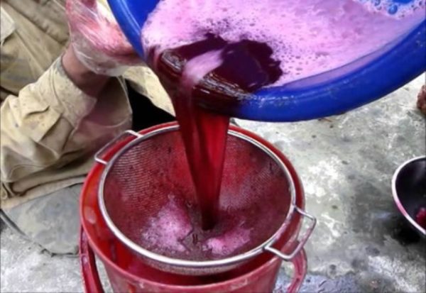 Процеживание виноградного сока через сито
