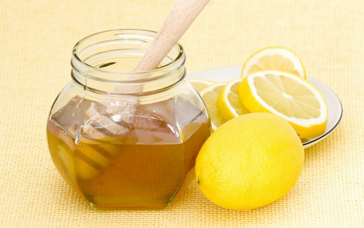 Мед в банке с деревянной ложкой и лимон