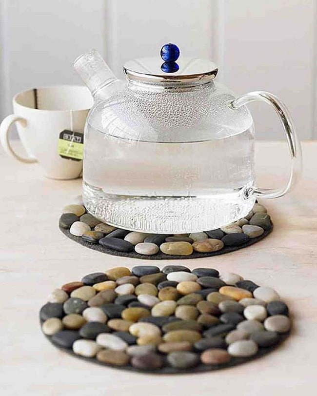 Приклеив гладкие камни к деревянному или резиновому основанию можно получить оригинальную подставку для чайника