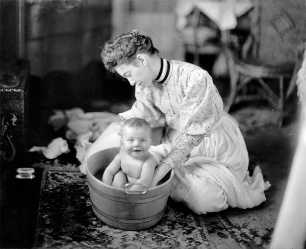 Ретро-фотография: женщина купает младенца