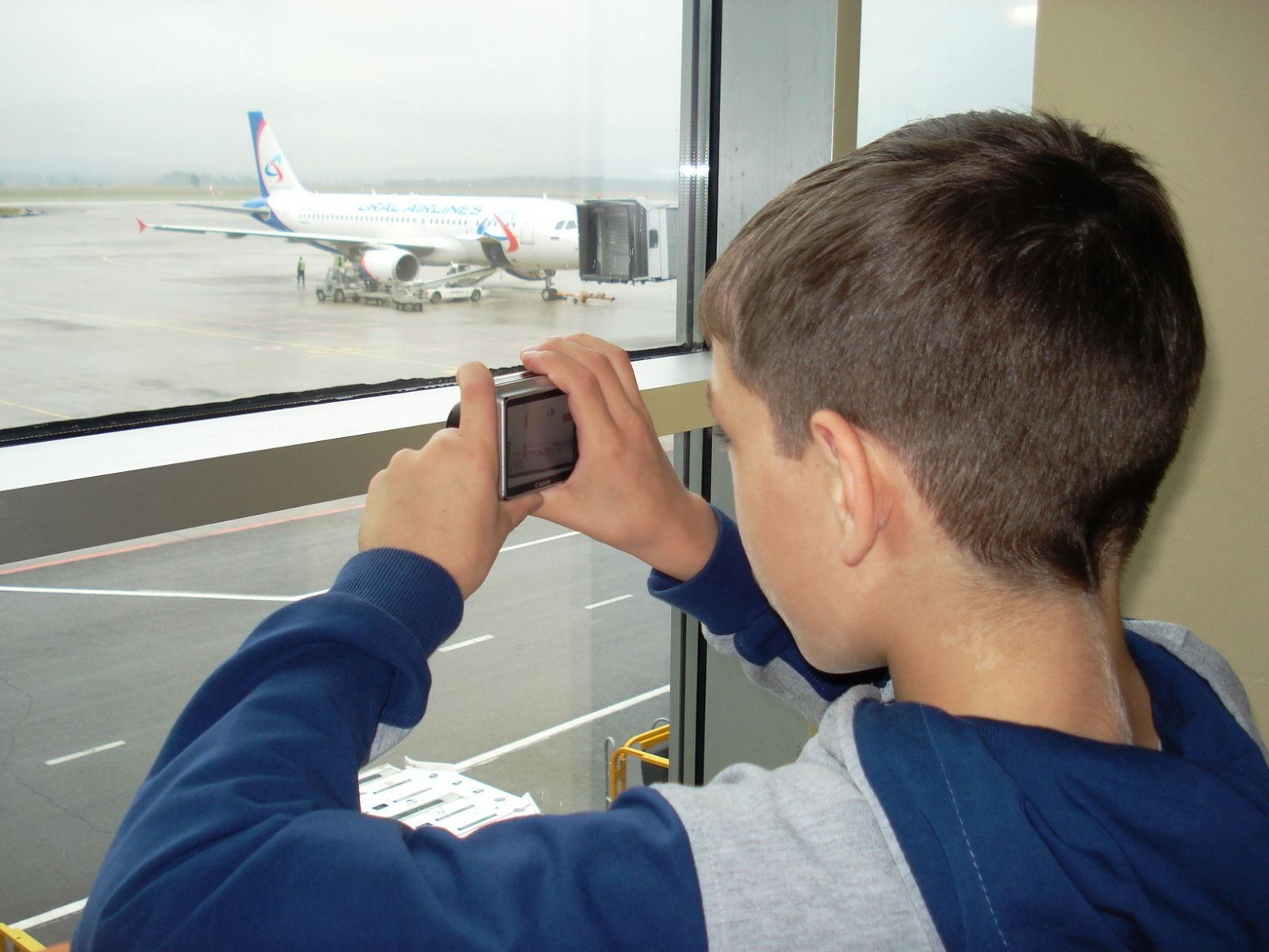 Мальчик фотографирует самолет
