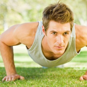 Physically fit boy doing push-ups at the park