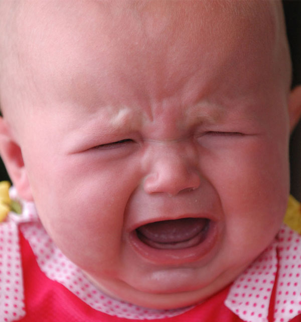 Резкий плач и вздутие животика являются симптомами колик у новорожденного