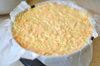 Смесь из овощей муки яиц сыра и масла выложена в форму застеленную бумагой для запекания