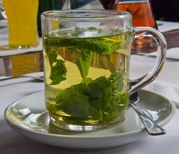 Чай из свежих листьев крыжовника в стеклянной кружке, народное тонизирующее средство