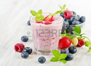 Raspberry smoothie with fresh berries on a wooden table . Selective focus