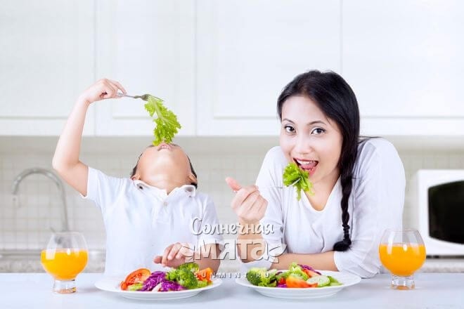 Мама с сыном едят свежий салат с витамином Е, фото